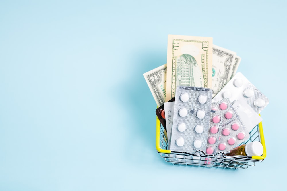 a shopping cart filled with pills and money