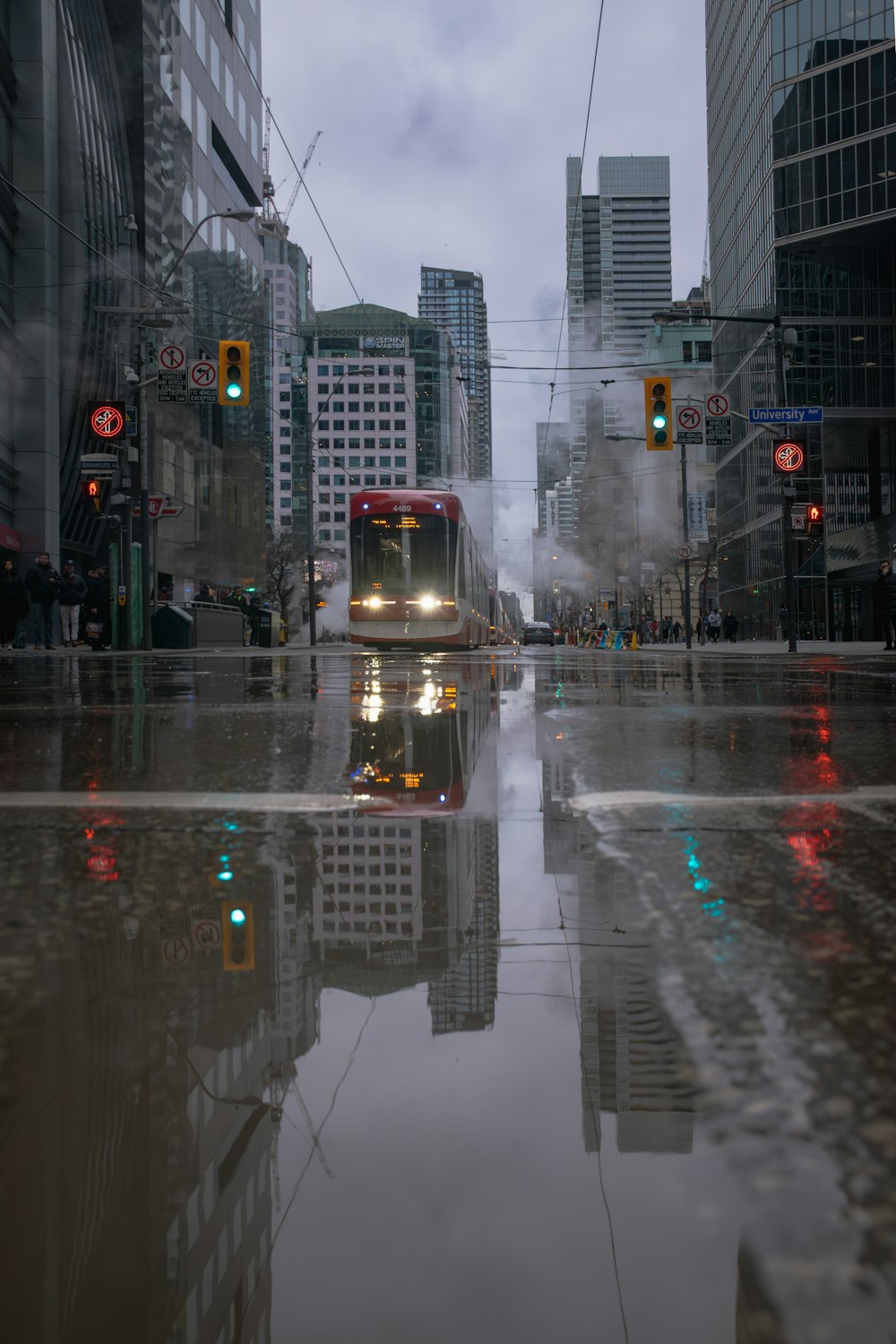 a city street with a train on a rainy day