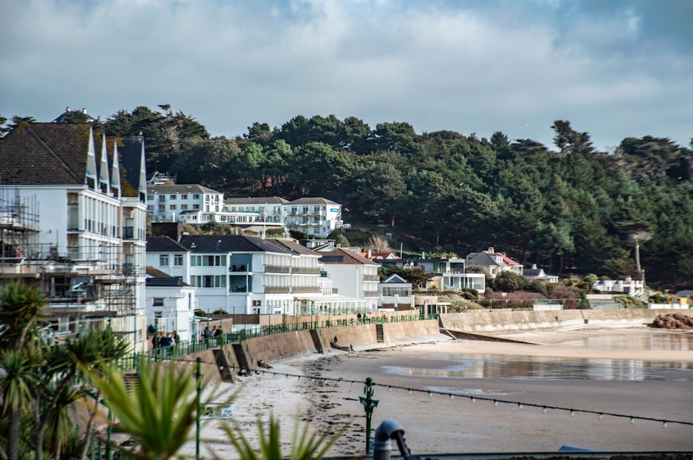 a row of houses on a beach next to a forest