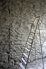 a ladder leaning against a stone wall