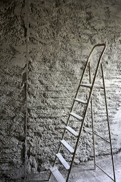 a ladder leaning against a stone wall