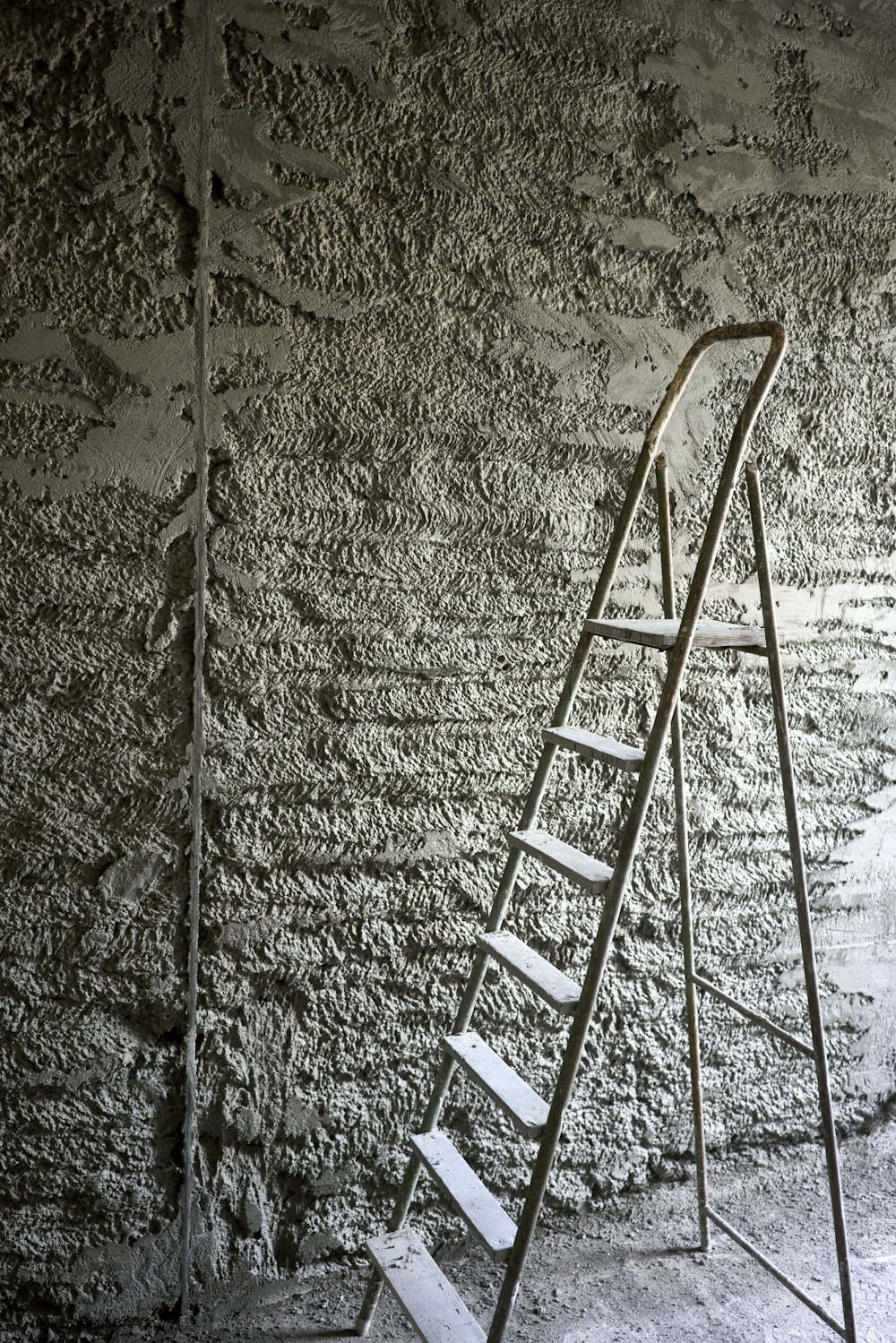 a ladder leaning against a stone wall