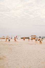 Players in vibrant blue and sand uniforms competing on a sunny beach soccer field in Naples.