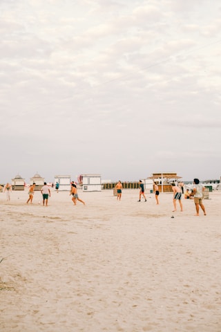 Players in vibrant blue and sand uniforms competing on a sunny beach soccer field in Naples.