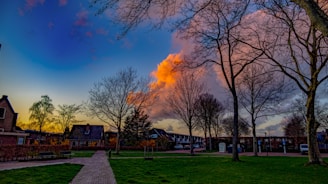 A clear sky with a glowing sunset over a quiet neighborhood.