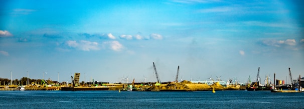 A skilled crew installing sheet piling along a waterfront site under a clear blue sky.