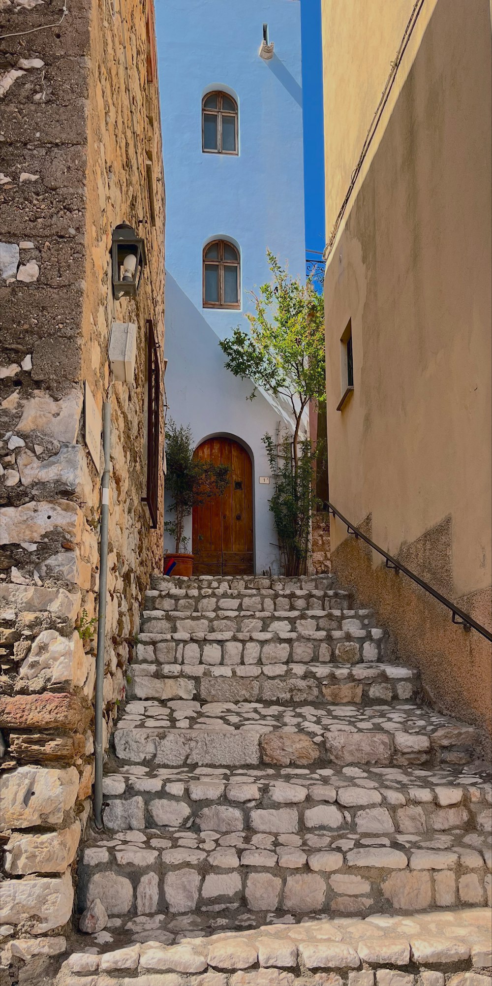 a cobblestone street with stone steps leading to a door