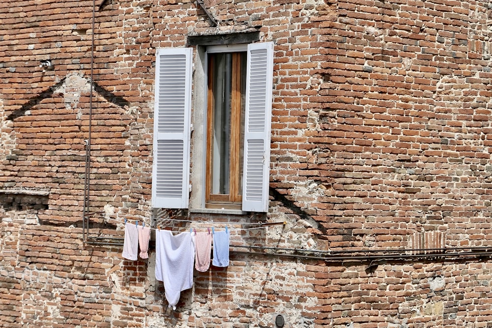 clothes hanging out to dry on a clothes line in front of a brick building