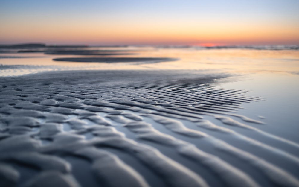 a sandy beach with waves coming in and out of the water