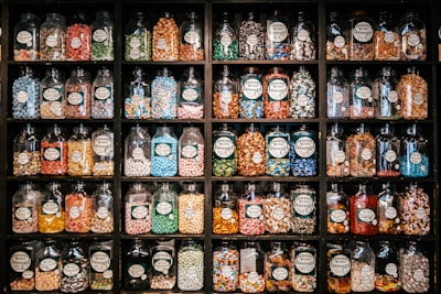 Shelves filled with various candy jars and packages inside a cozy store.