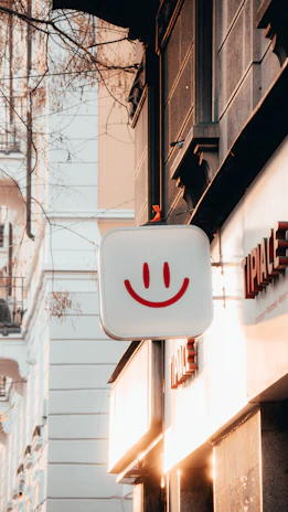 Traditional illuminated advertising sign glowing warmly on a city street at dusk