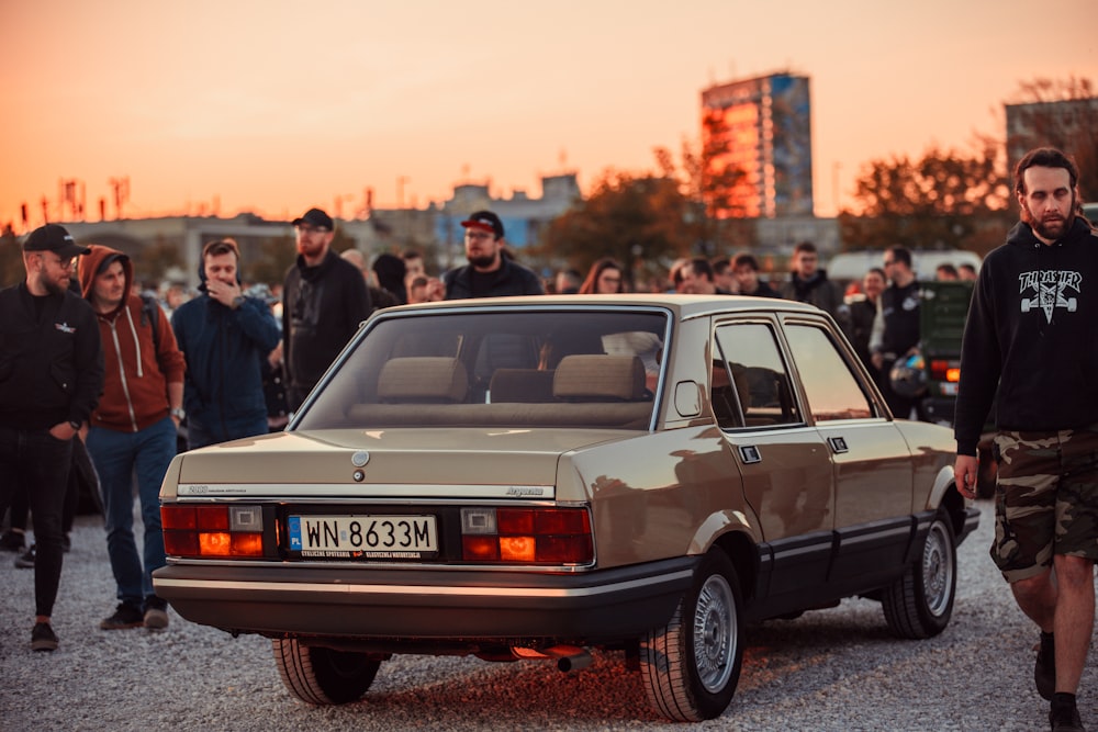 a group of people standing around a car