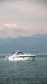 A sleek motorboat cruising on a calm lake under clear skies.