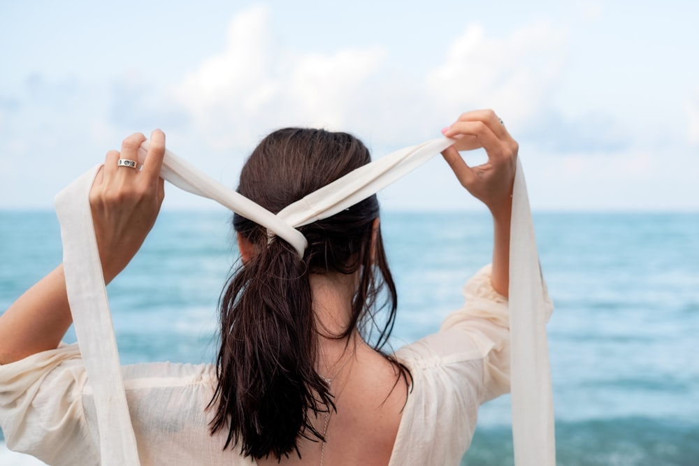 a woman holding a white scarf over her head