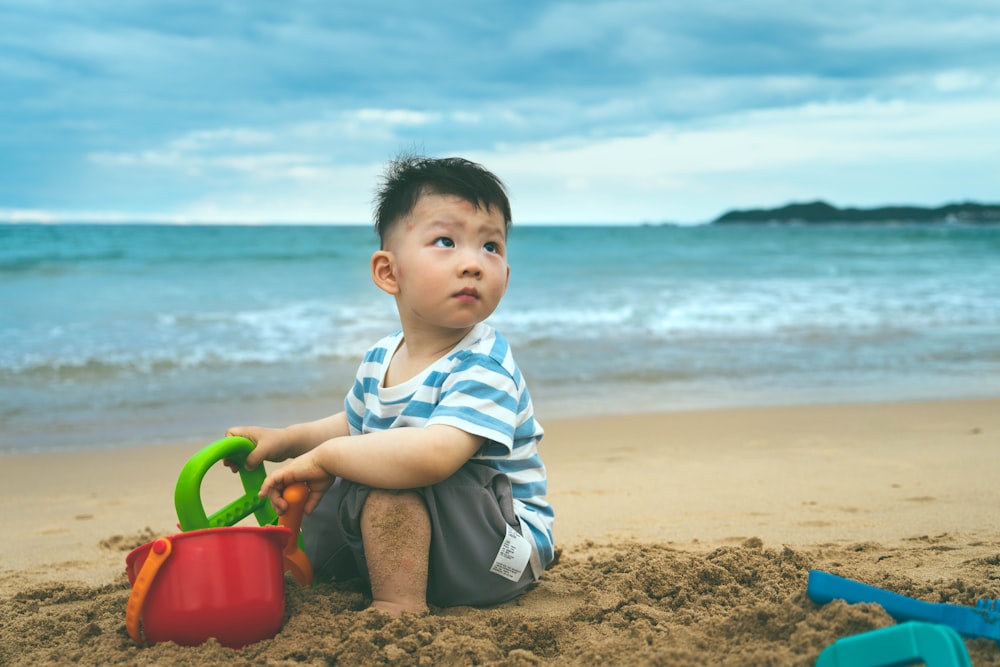 Un niño pequeño jugando en la arena de la playa