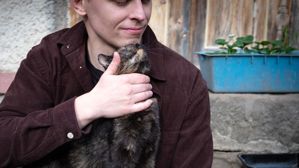 Un hombre sosteniendo un gato en sus manos