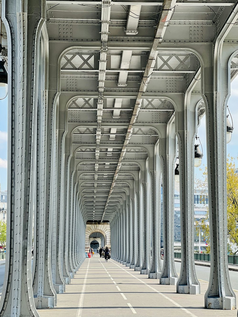 persone che camminano lungo una lunga passerella sotto un ponte