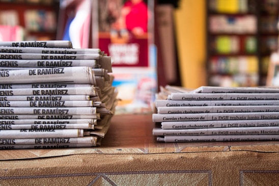 a stack of newspapers sitting on top of a table
