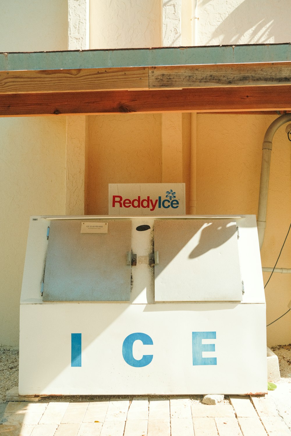 a white ice box sitting under a wooden roof