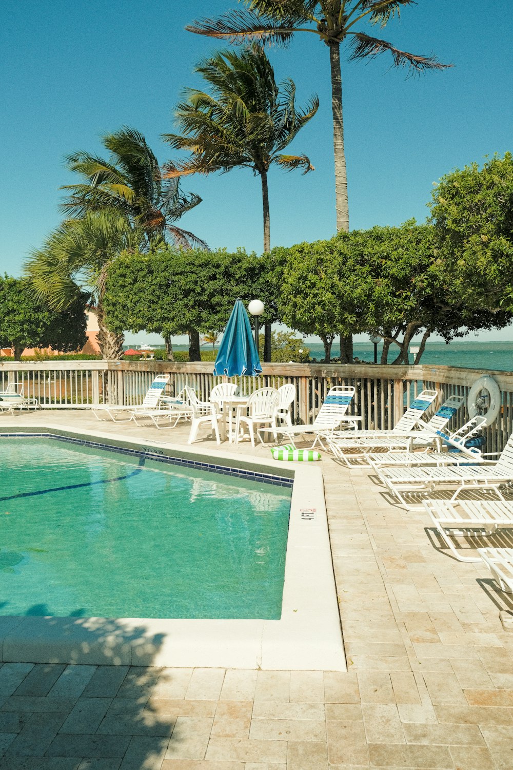 a swimming pool with chairs and umbrellas around it