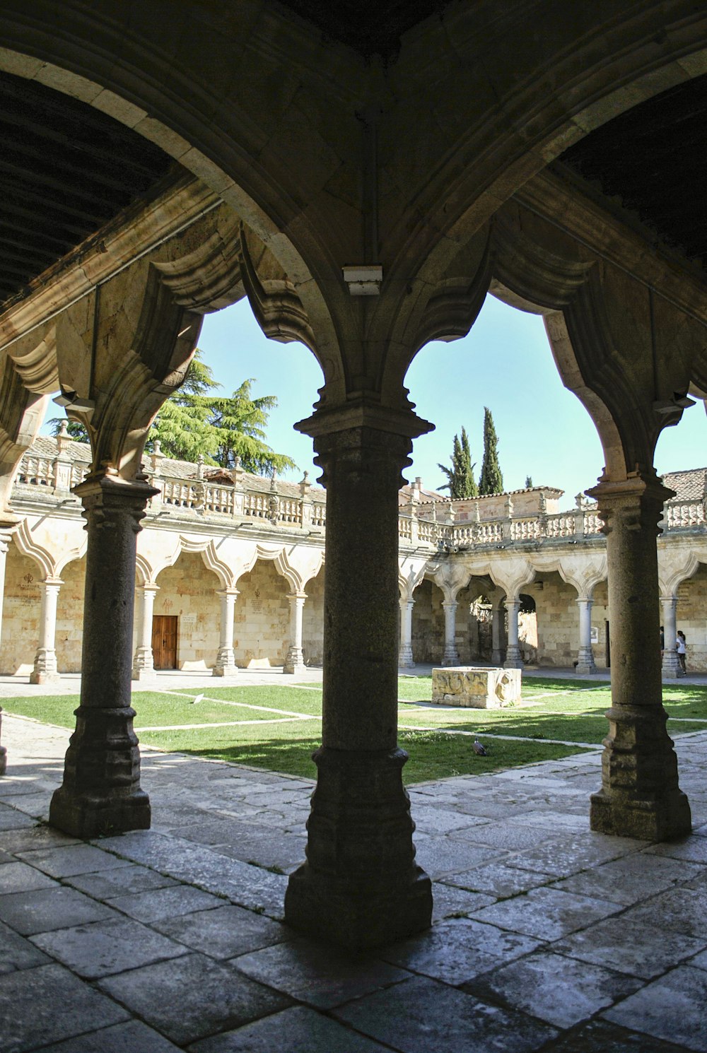 a view of a courtyard through a stone archway