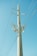 A tall electricity pole stands against a clear blue sky, with multiple lines of cables stretching outwards. The pole is equipped with insulators and other electrical components.
