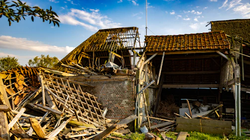 Emergency team from Mr Couverture fixing a damaged roof after a storm at dusk.