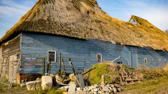 A damaged traditional Norwegian log house (laftebygg) showing visible wear and structural issues.