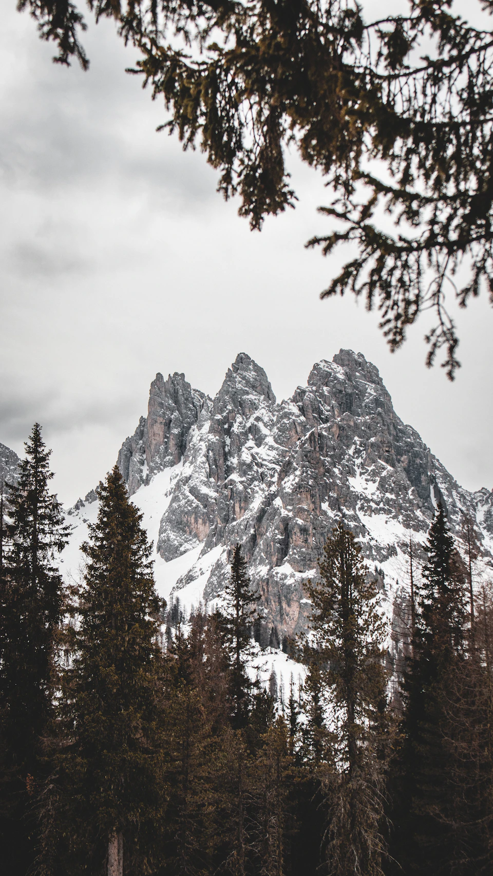 Majestic mountain range with three peaks standing tall against an overcast sky backdrop