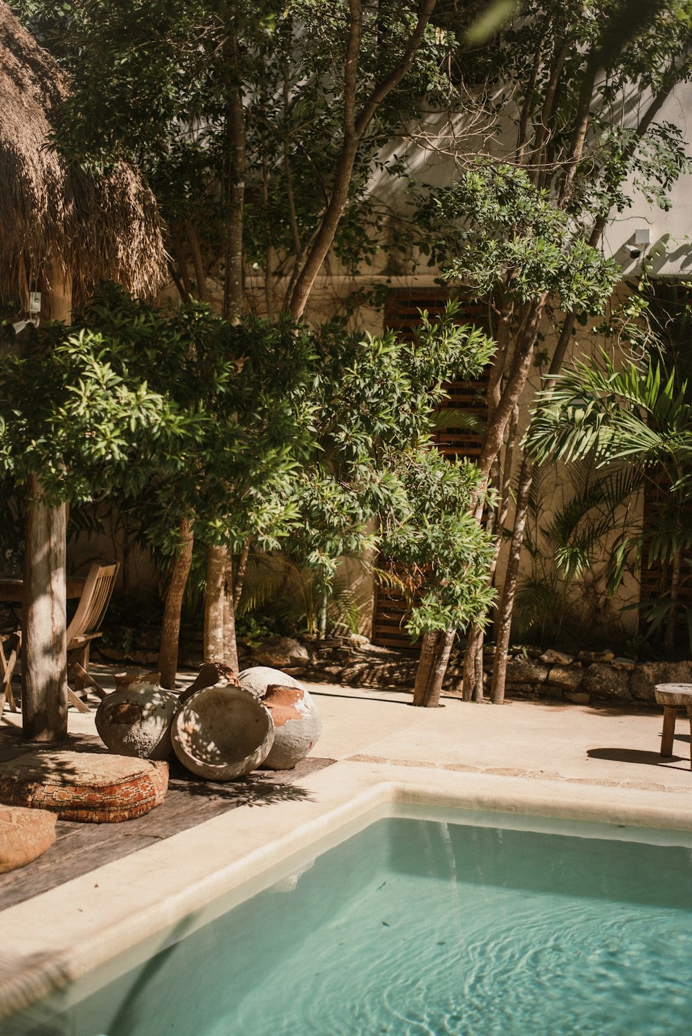 a swimming pool surrounded by trees and chairs