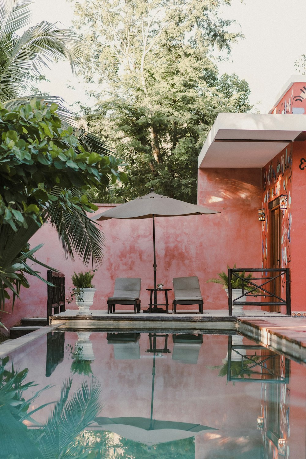 a pool with chairs and an umbrella next to it