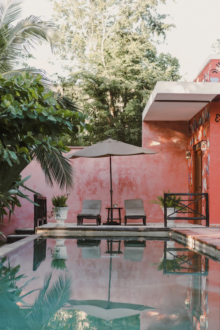 A pool with lounge chairs and an umbrella
