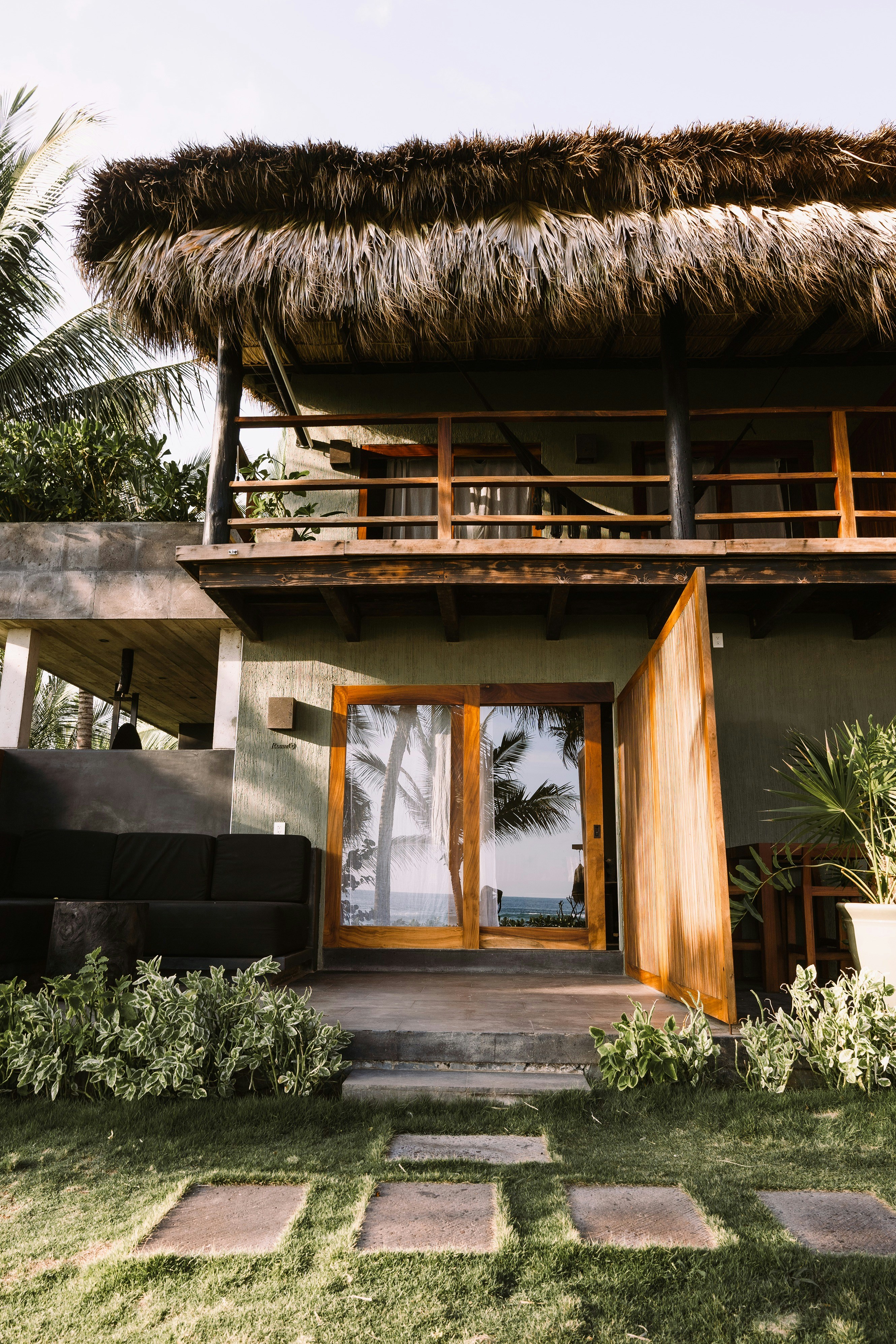 a house with a thatched roof and wooden doors