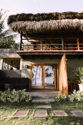 a house with a thatched roof and wooden doors