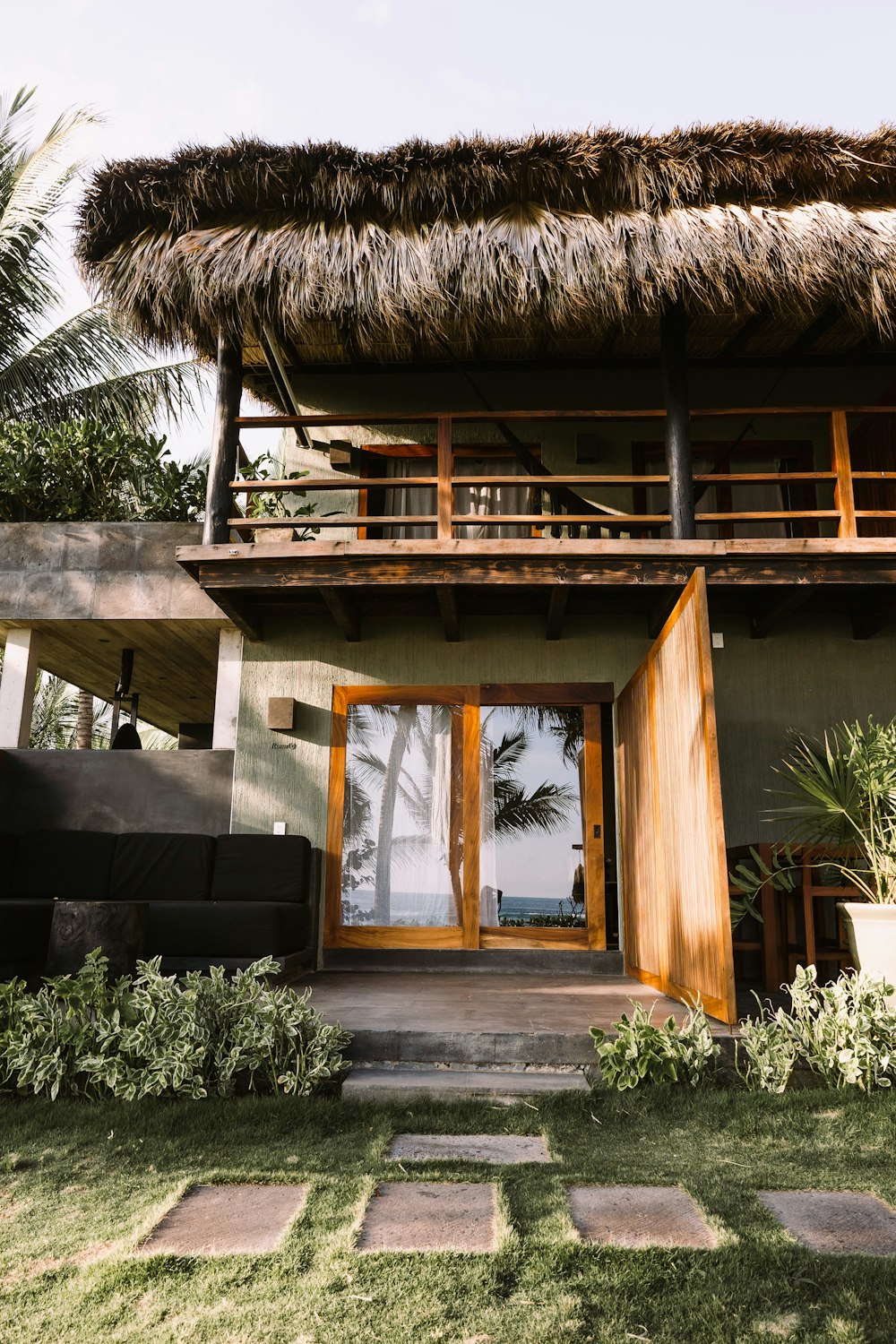 a house with a thatched roof and wooden doors