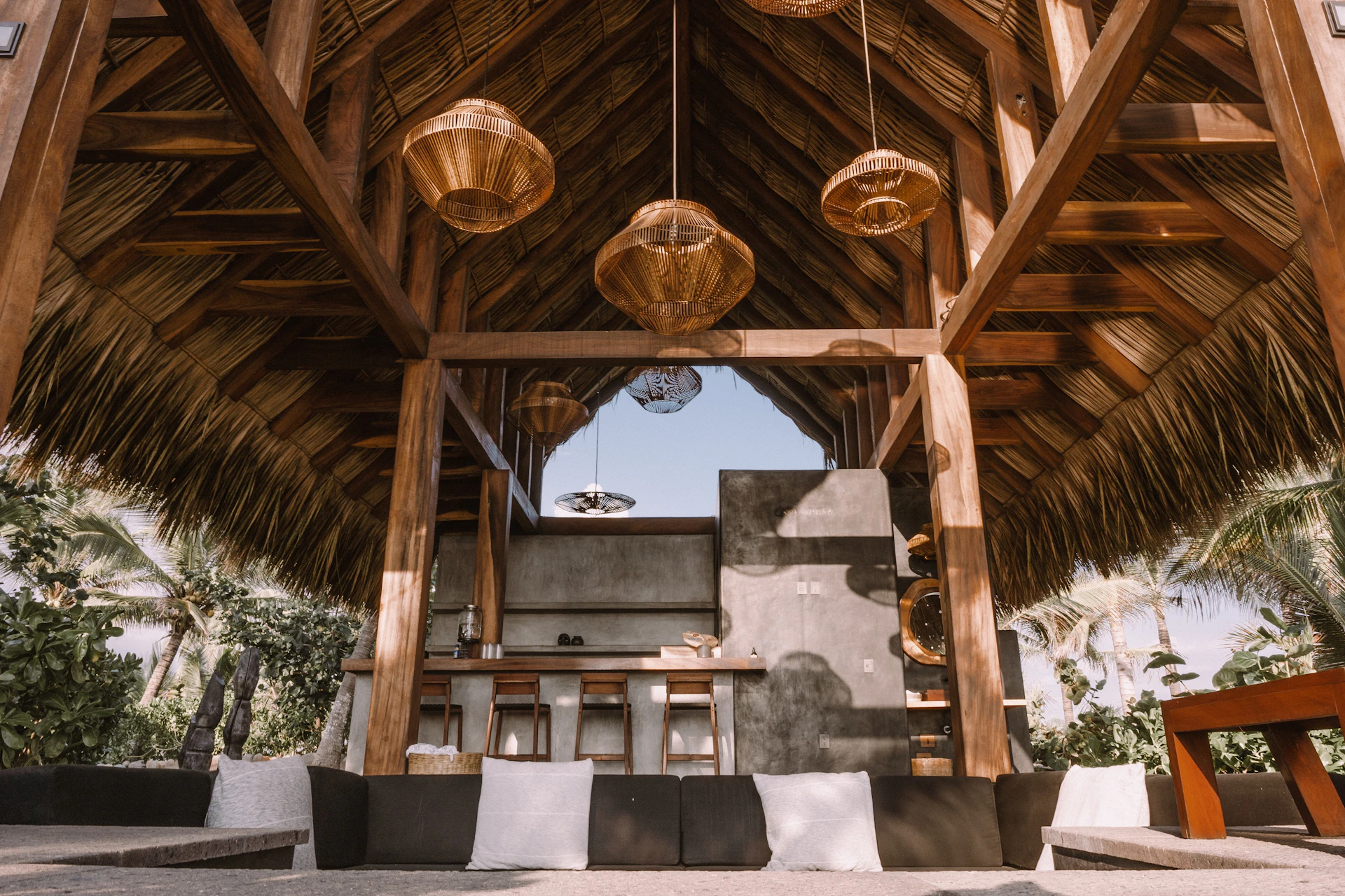 Terraza de madera del lodge iluminada al anochecer, rodeada de bosque al pie del Volcán Arenal
