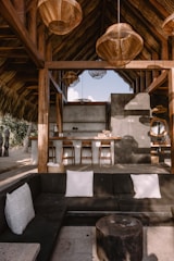 a living room filled with furniture under a wooden roof