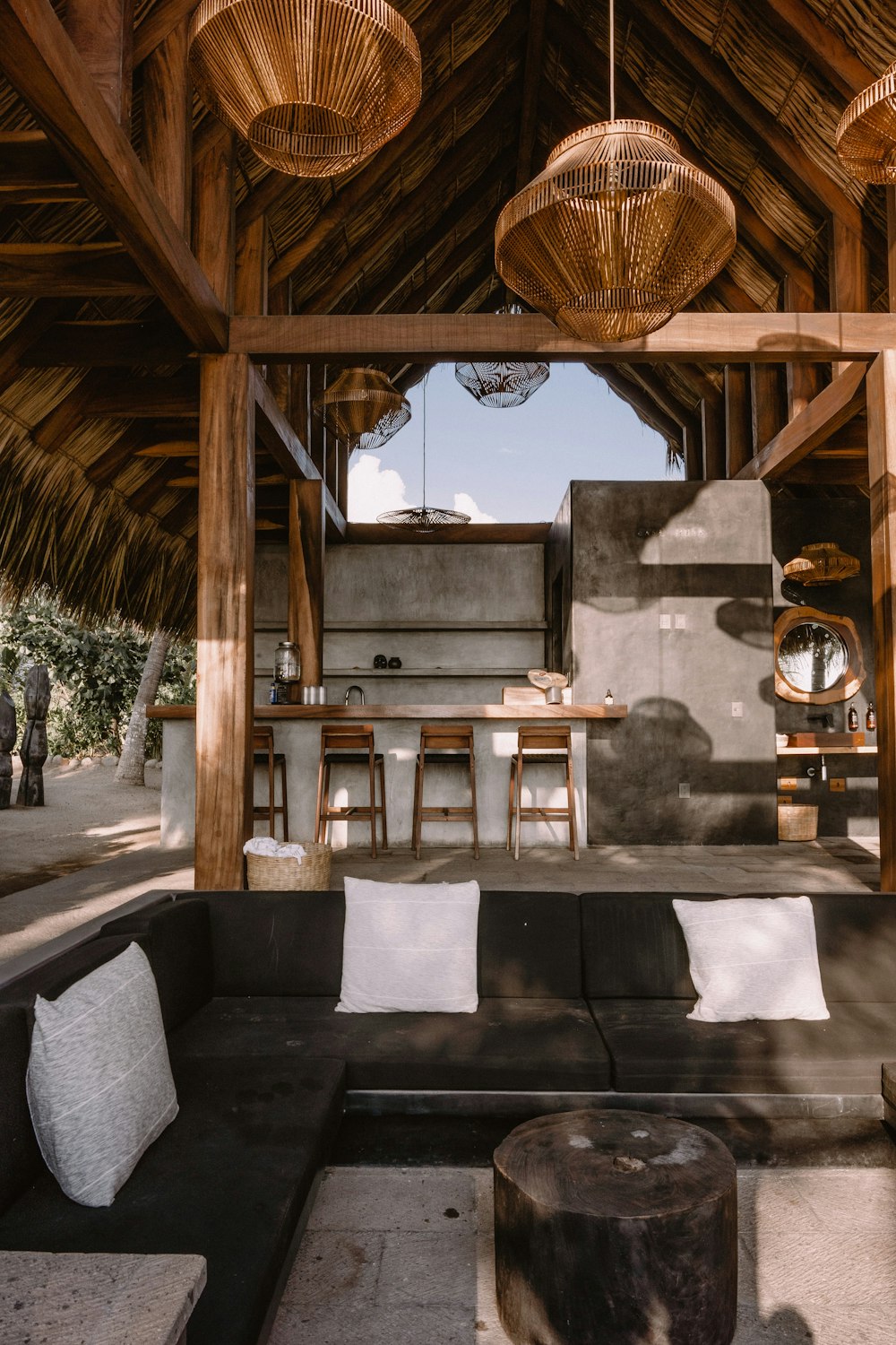 a living room filled with furniture under a wooden roof