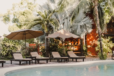 a couple of lawn chairs sitting next to a swimming pool