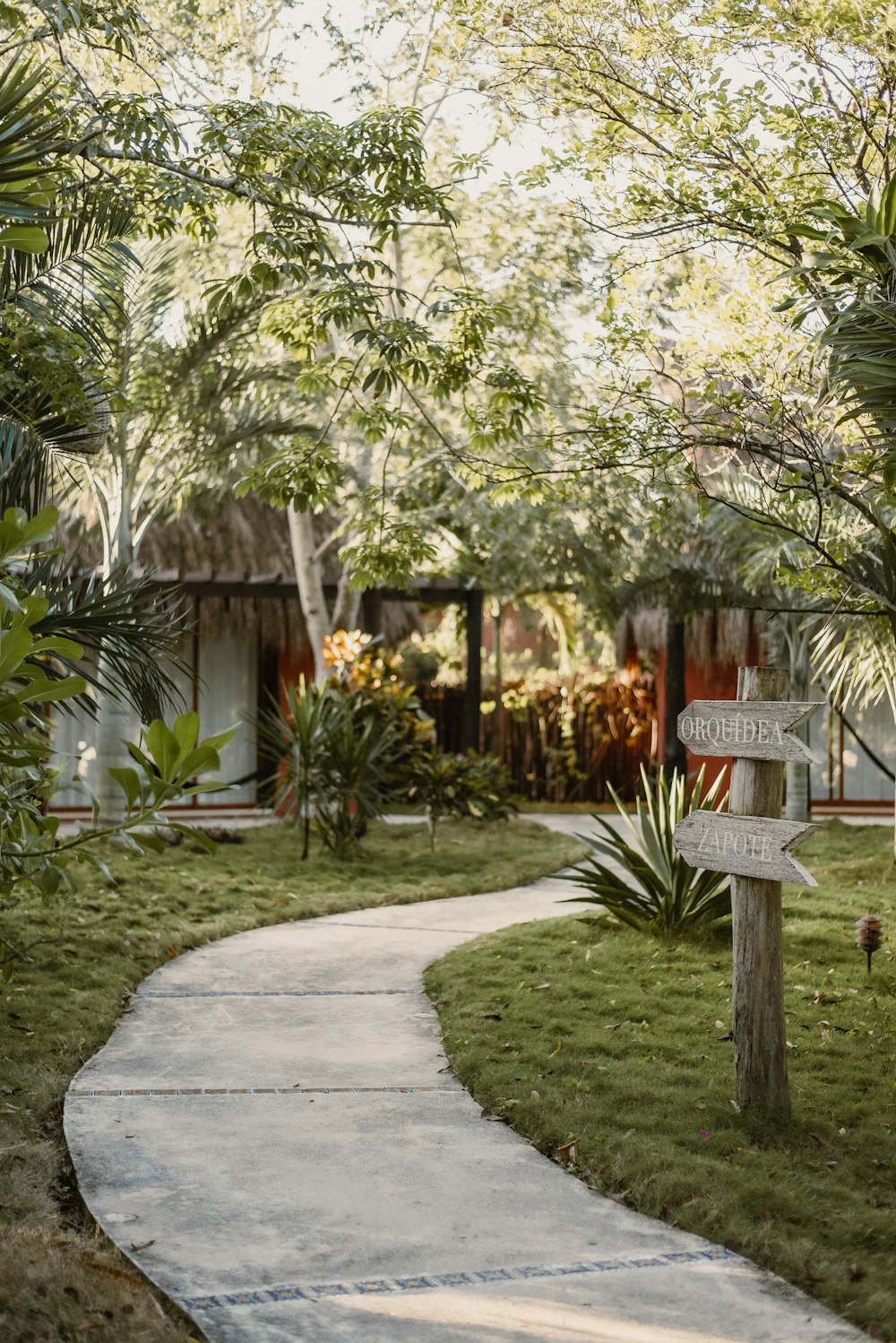 a path leading to a house with a sign on it