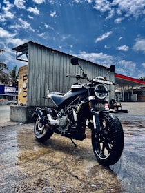 A sleek motorcycle parked beside a modern building under clear skies.