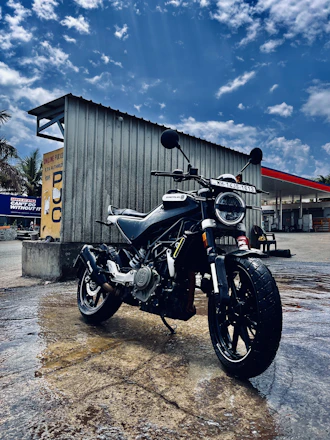 A sleek motorcycle and a modern car parked side by side under a clear sky.