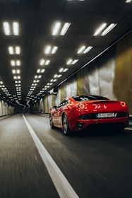 Dynamic shot of a sports car speeding through a dark tunnel with glowing red brake lights.