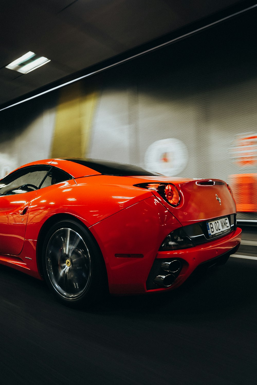 um carro esportivo vermelho dirigindo através de um túnel