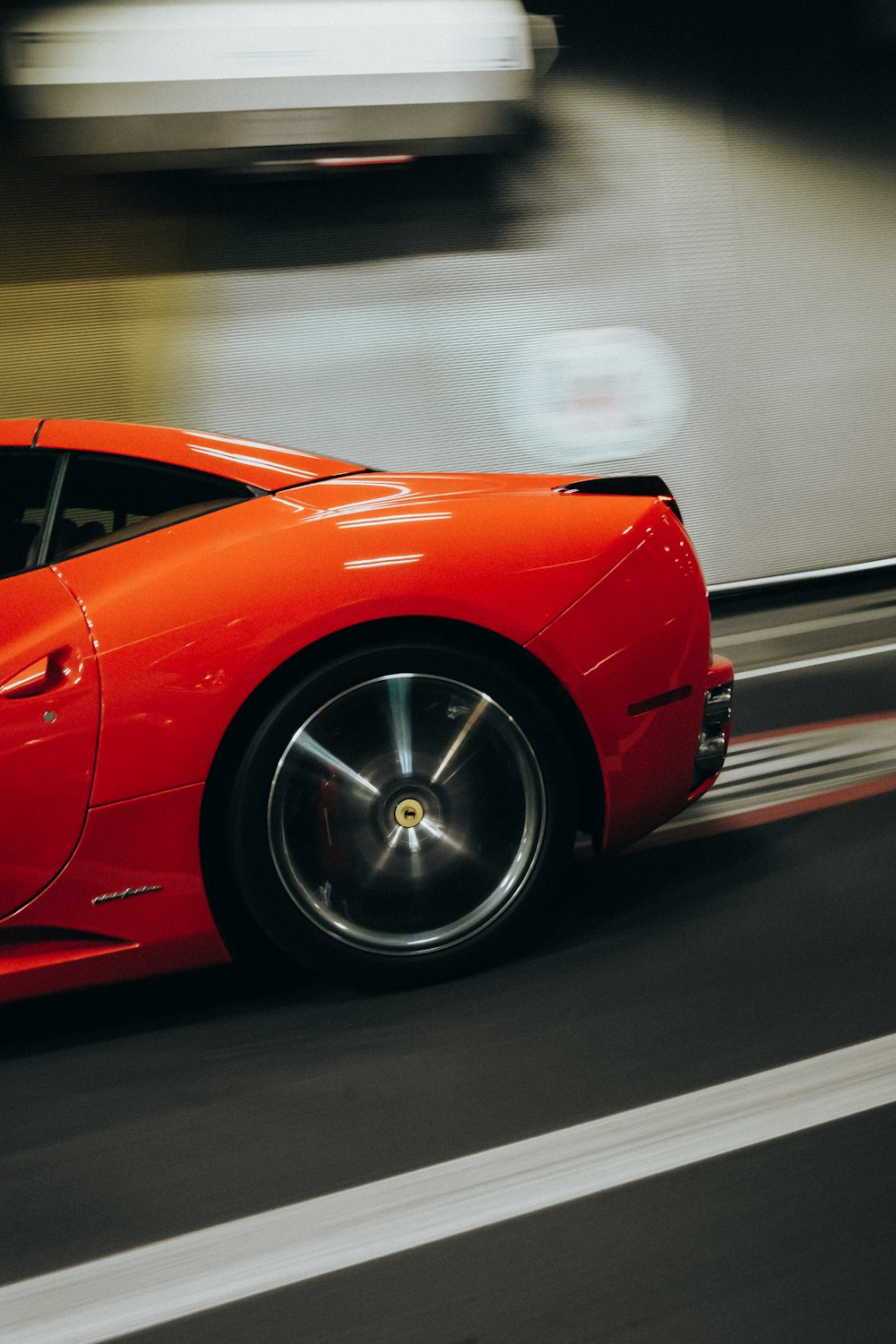 a red sports car driving down a street