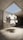 A 3D-rendered monkey head, stylized and cartoonish, floats in a concrete room with a skylight opening showing a clear blue sky. The setting is minimalist with stark shadows.