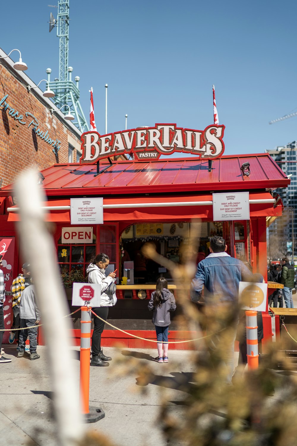 people are standing outside of a small restaurant