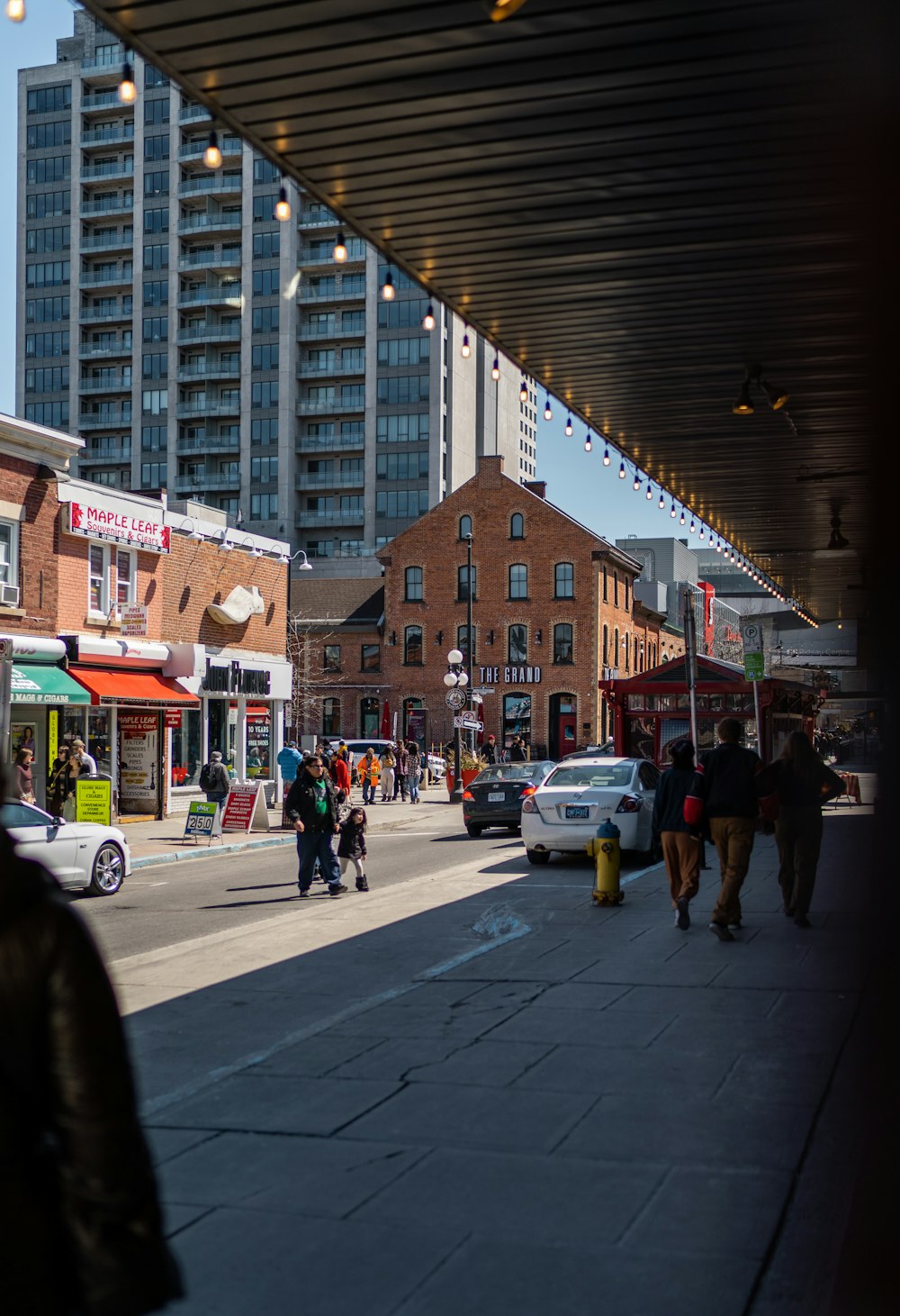 a group of people walking down a street next to tall buildings