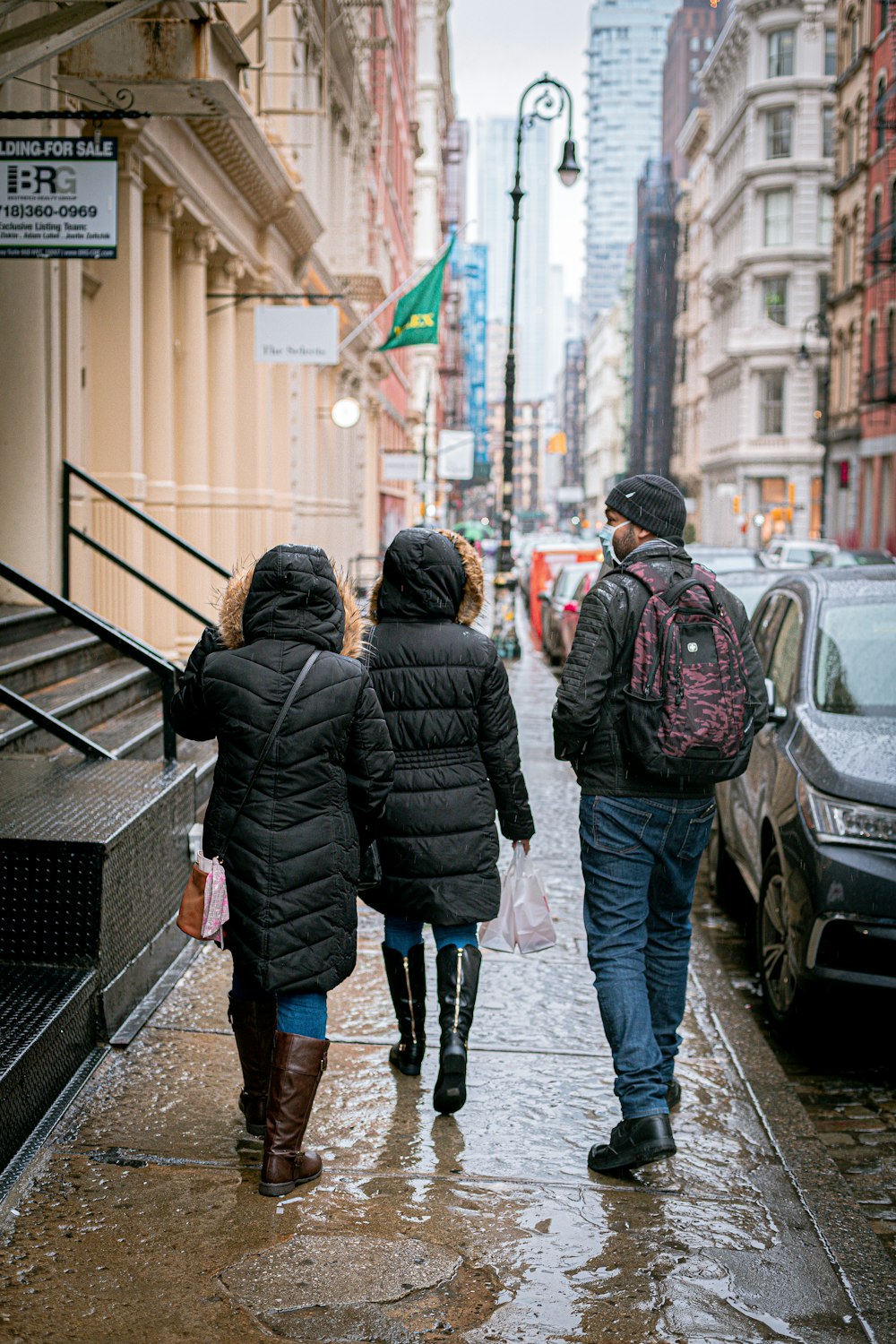 a group of people walking down a street in the rain