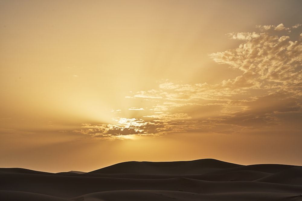 the sun is setting over the sand dunes